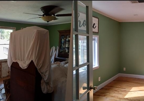 A bedroom with a bed and a ceiling fan, showcasing interior painting services in Cave Spring