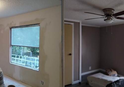 A room with a ceiling fan and a window, part of interior painting services in Cave Spring